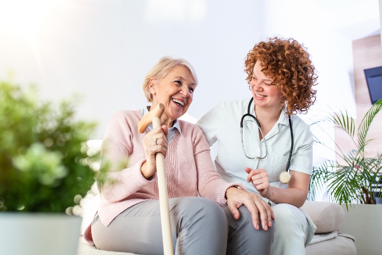 friendly-relationship-smiling-caregiver-uniform-happy-elderly-woman-supportive-young-nurse-looking-senior-woman-1